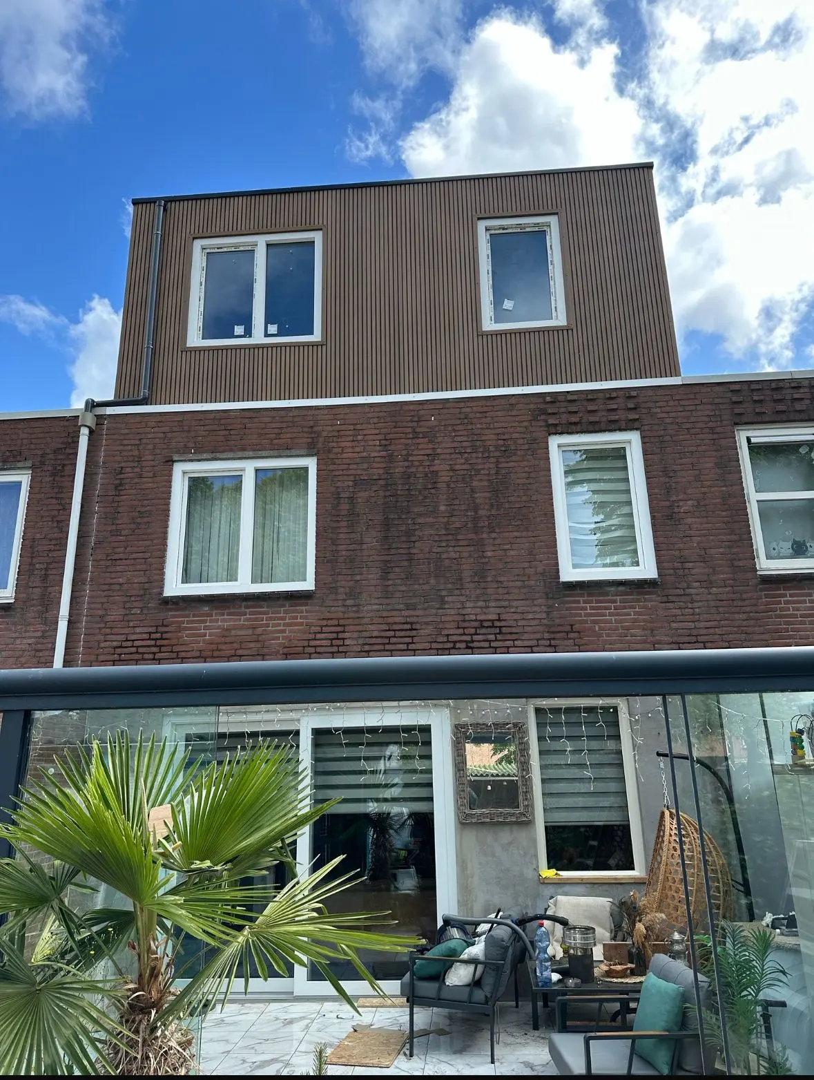 Opgeleverde dakopbouw in Rotterdam: extra verdieping op een rijwoning met verticale gevelbekleding en nieuwe kozijnen