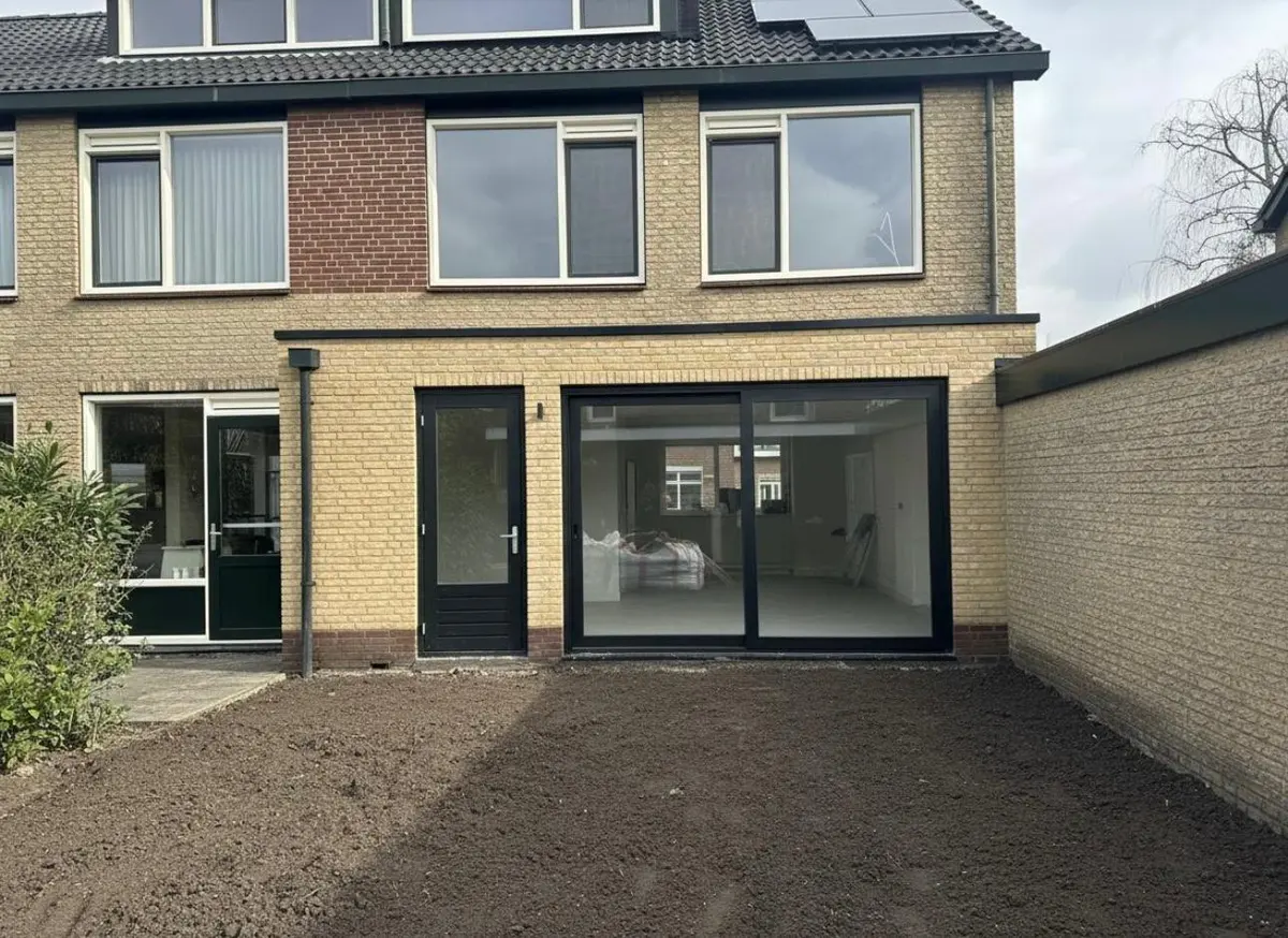 Opgeleverde uitbouw aan de achtergevel met grote glazen schuifpui en nieuw metselwerk