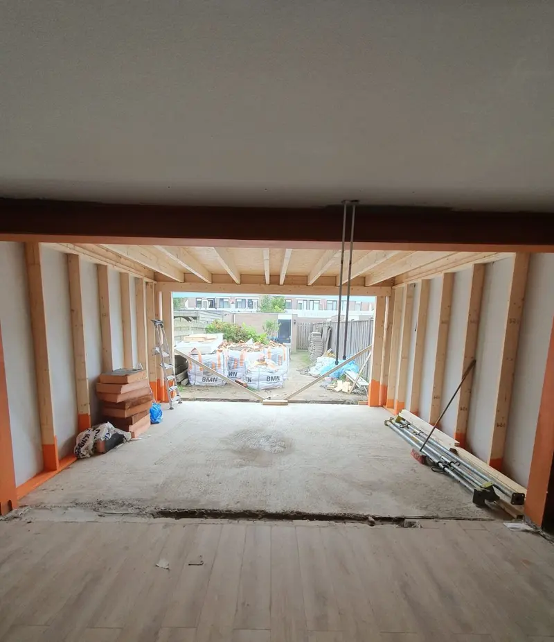 Uitbouw in aanbouw in Etten-Leur, gezien vanuit de woonkamer: de doorbraak is opgevangen met een stalen ligger, daarachter de houtskeletwanden en de nieuwe vloer