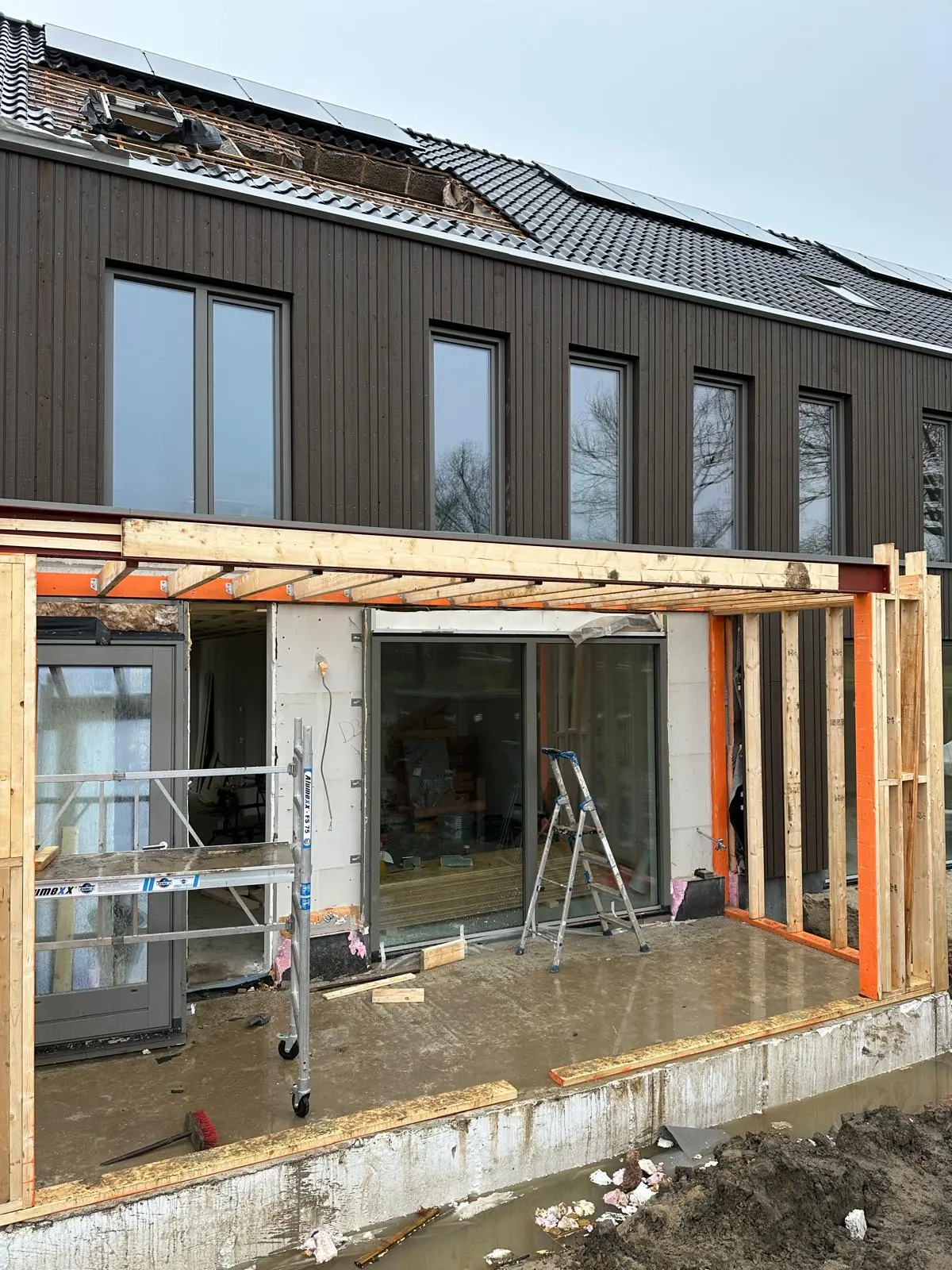 Uitbouw in aanbouw: dakconstructie en pui geplaatst
