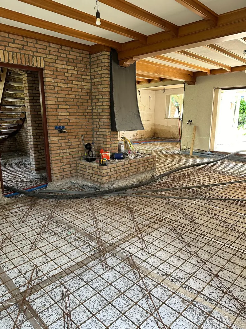 Voorbereiding van een nieuwe vloeropbouw met wapening en leidingen