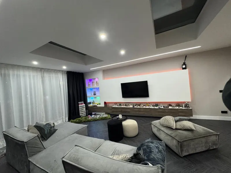 Woonkamer met verlaagd plafond en inbouwspots na renovatie